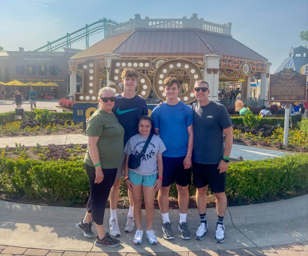 Family posing for a photo in front of the Cedar Point Carousel